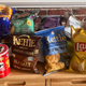 Several brands of supermarket potato chips on kitchen counter